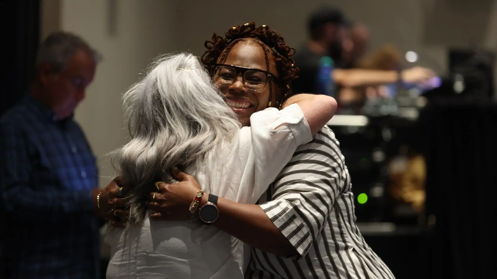 Two women embracing warmly at an Ignite community gathering