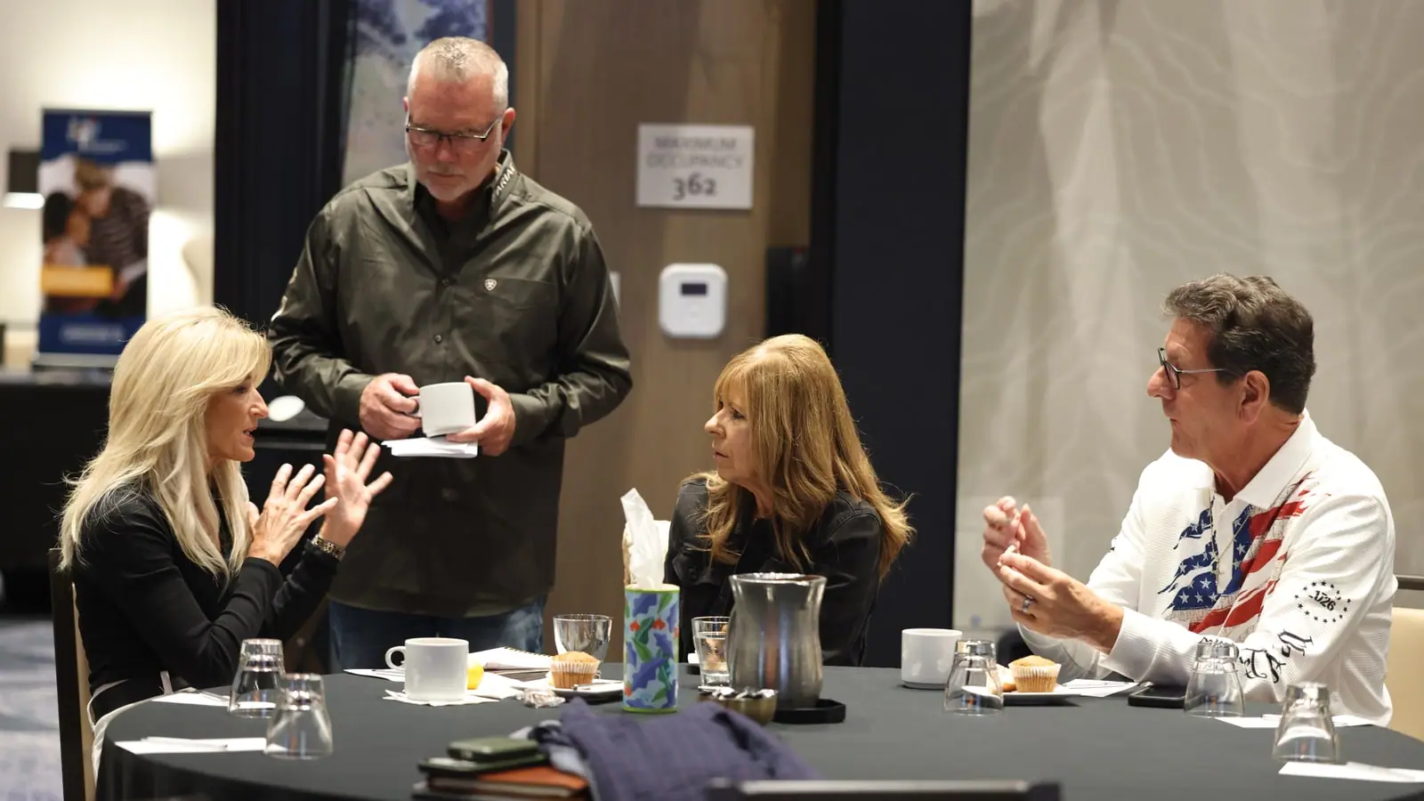 Business leaders in a focused conversation around a table at an Ignite gathering
